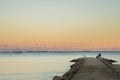 At sunset, people sit on a bench on the pontoon Royalty Free Stock Photo